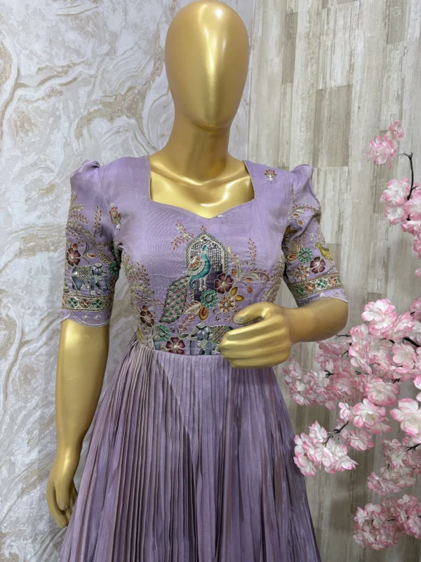 Designer tissue long gown with heavy flare & fine pleating and beautiful meenakari work on yoke part