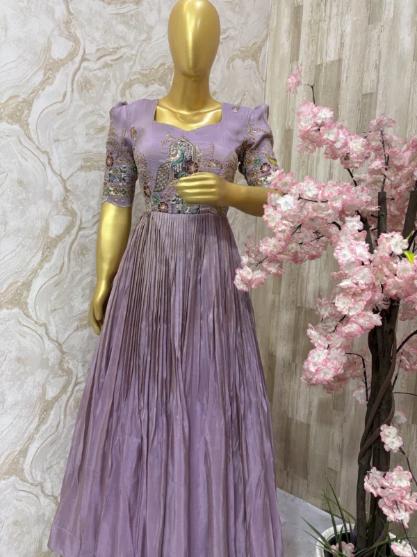 Designer tissue long gown with heavy flare & fine pleating and beautiful meenakari work on yoke part