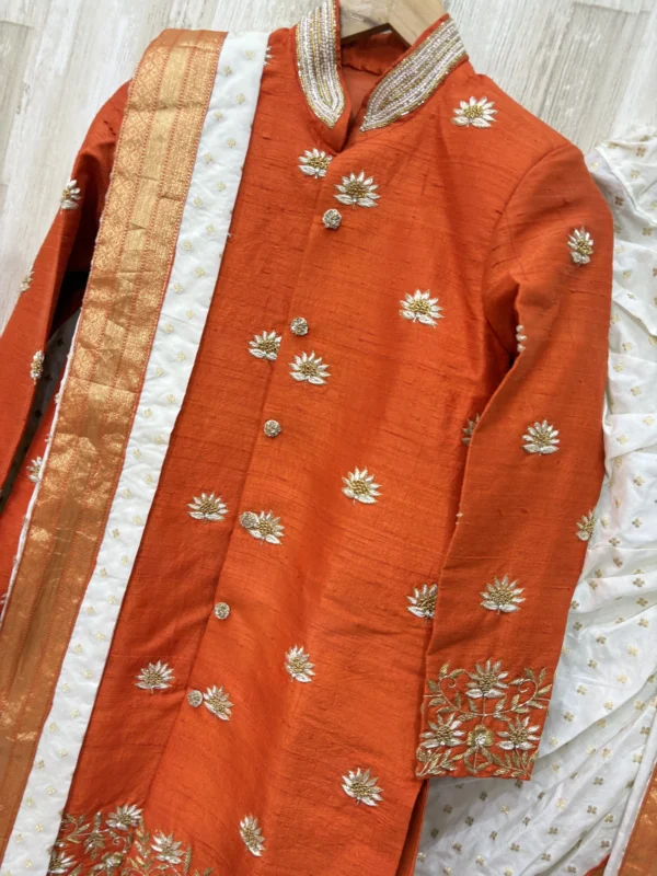 Pure raw silk Orange sherwani with heavy maggam work paired with kanduva & dhoti